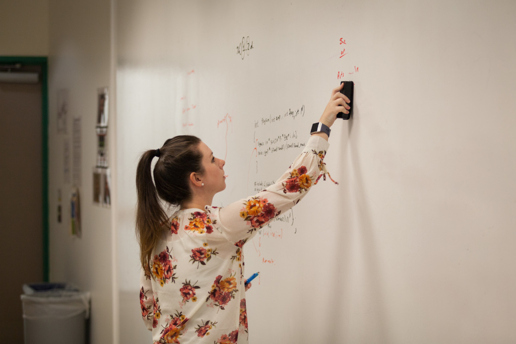 women writing on whiteboard